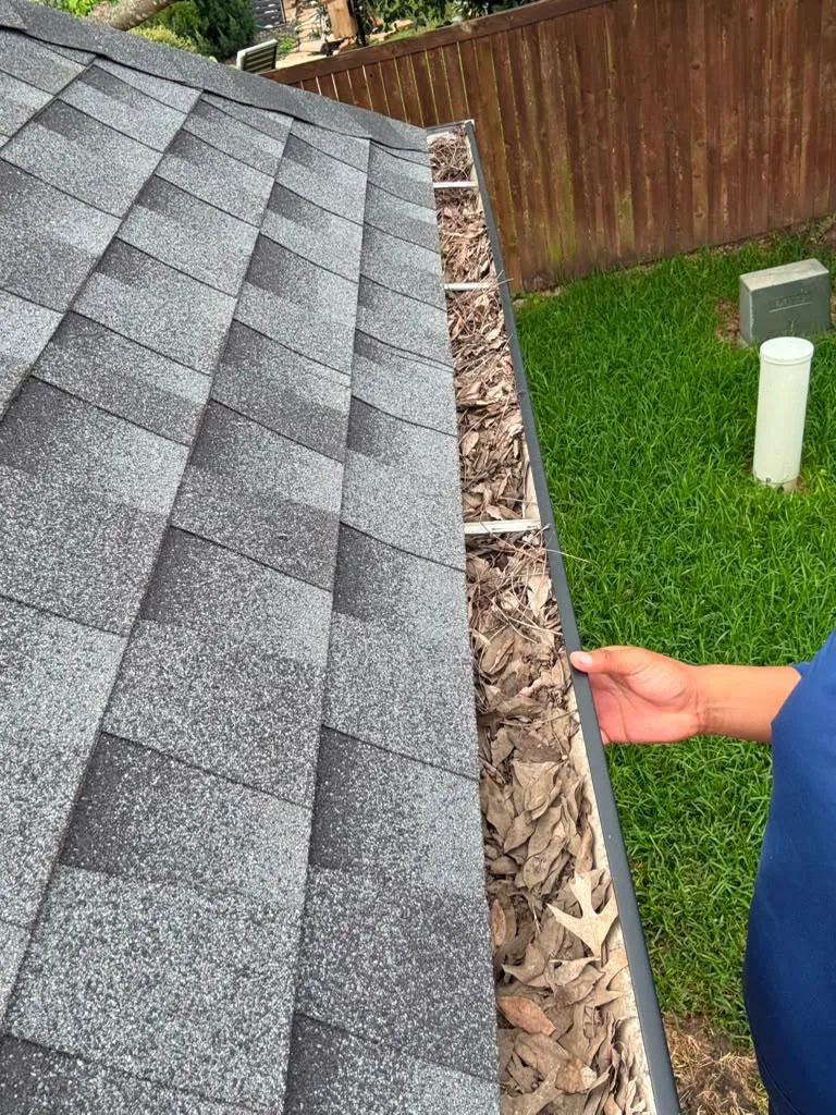 Gutter cleaning — leaves and debris cleared from a gutter in Dallas–Fort Worth