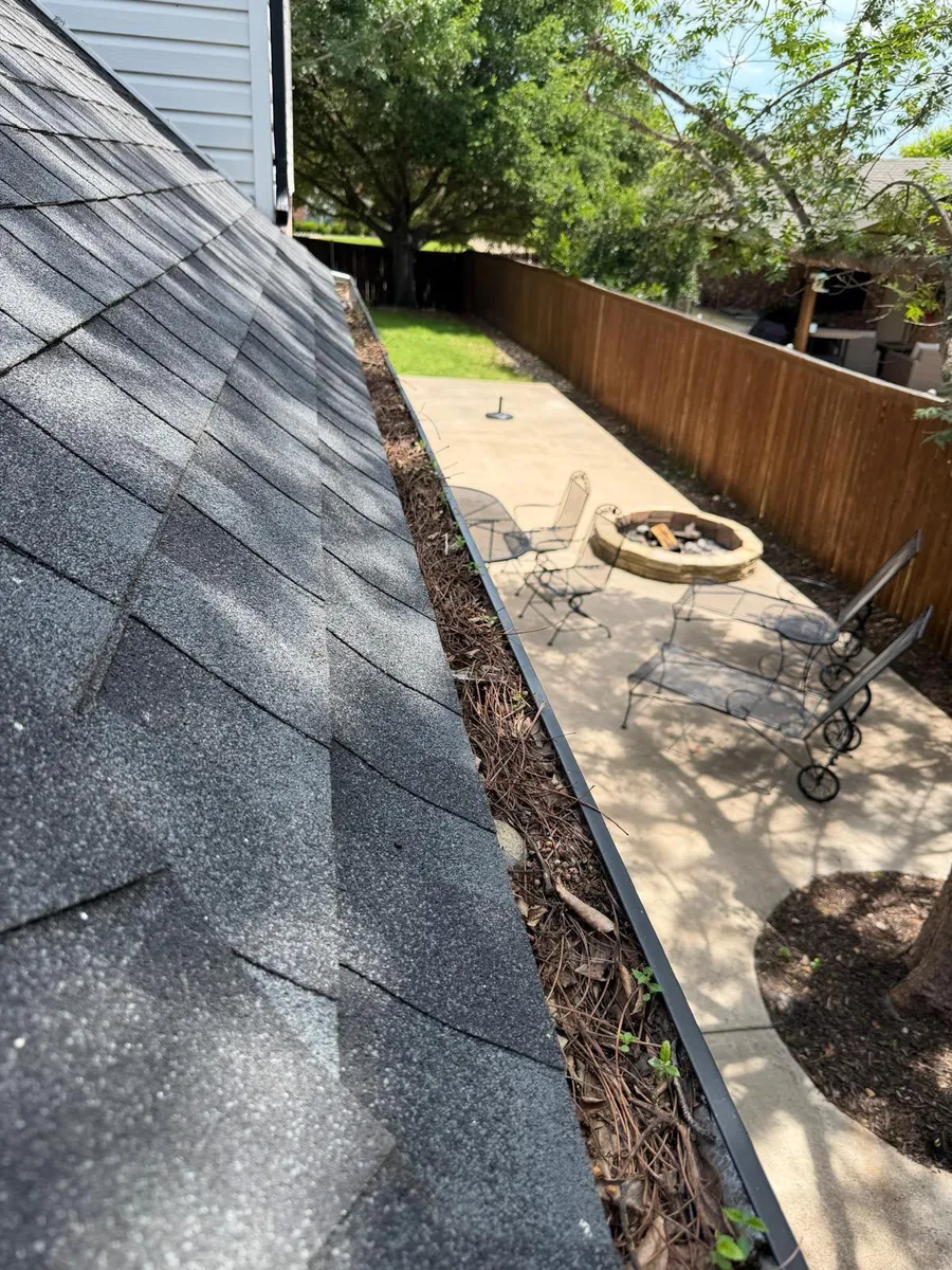 Gutter cleaning — debris in the gutter before cleaning in Dallas–Fort Worth