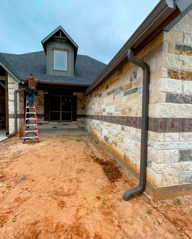 Technician installing a new downspout McKinney TX