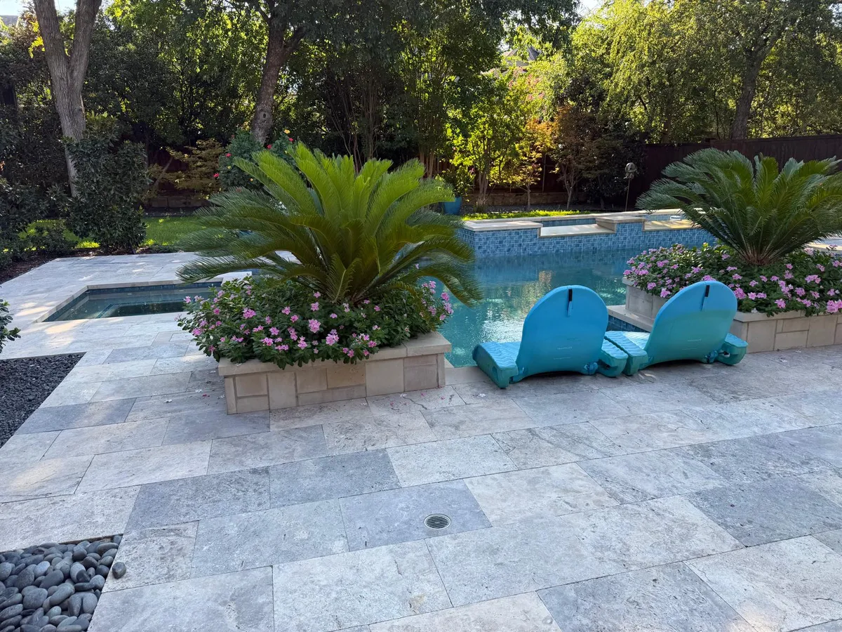 Travertine pool deck with tropical landscaping Dallas Fort Worth TX