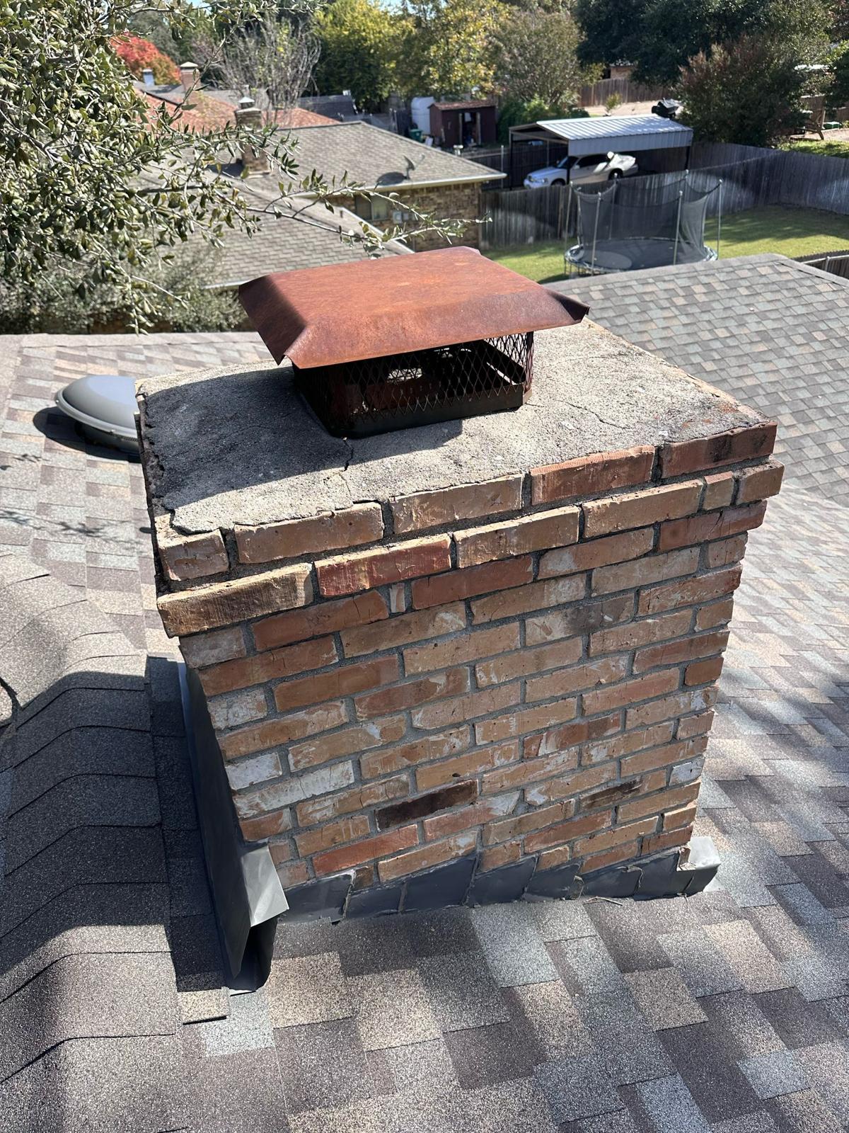 Chimney before repair — cracked crown, rusted cap, failing mortar joints — Dallas TX