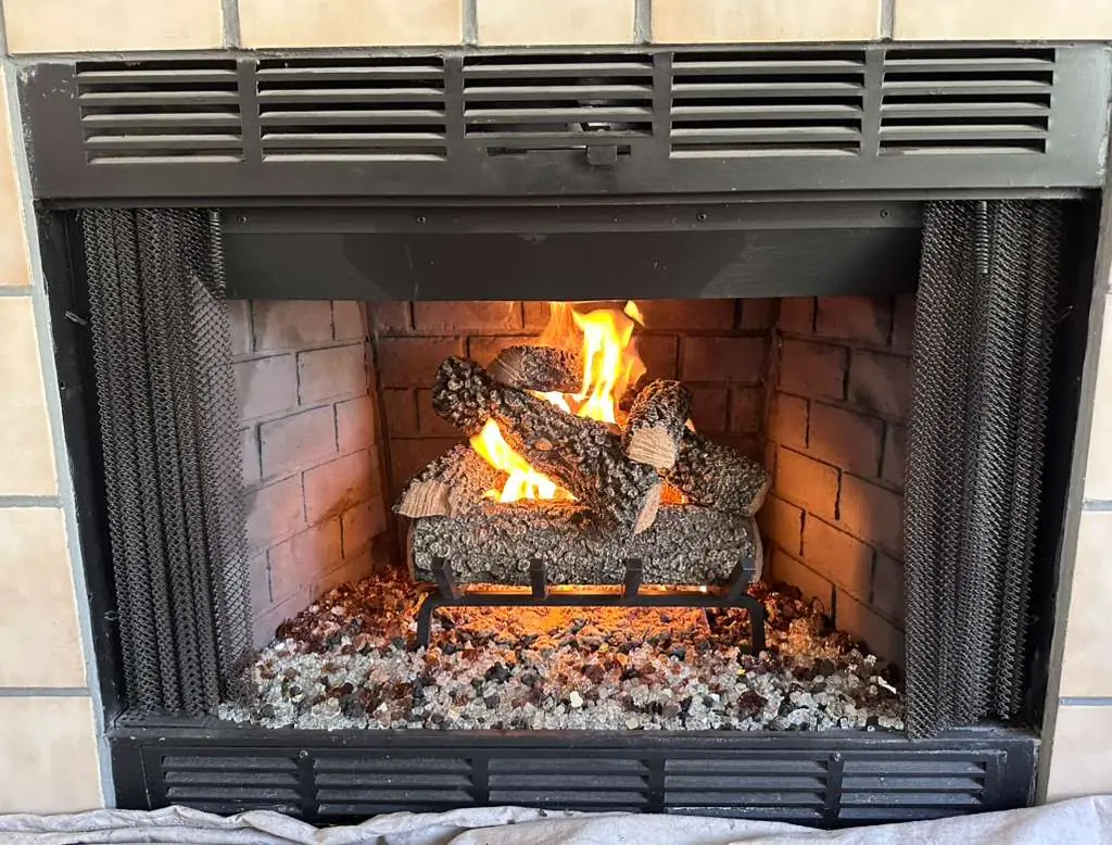 Fireplace after cleaning and upgrade — decorative logs and fire glass installed — Dallas TX