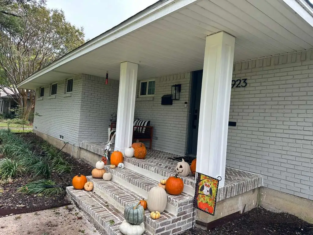 Front porch with natural stone-clad columns and slate tile steps — after masonry upgrade